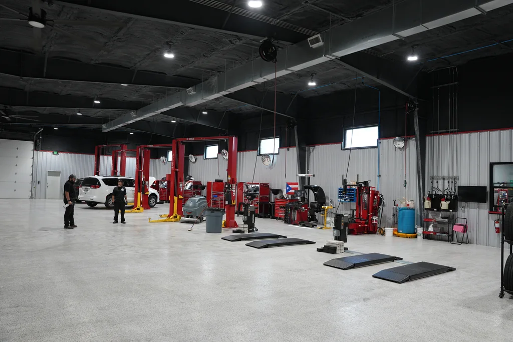 Service workshop floor with red lifts and tire service equipment.